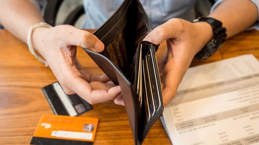 You say you'll pay off debt when you have the money. person opening wallet without cash inside it