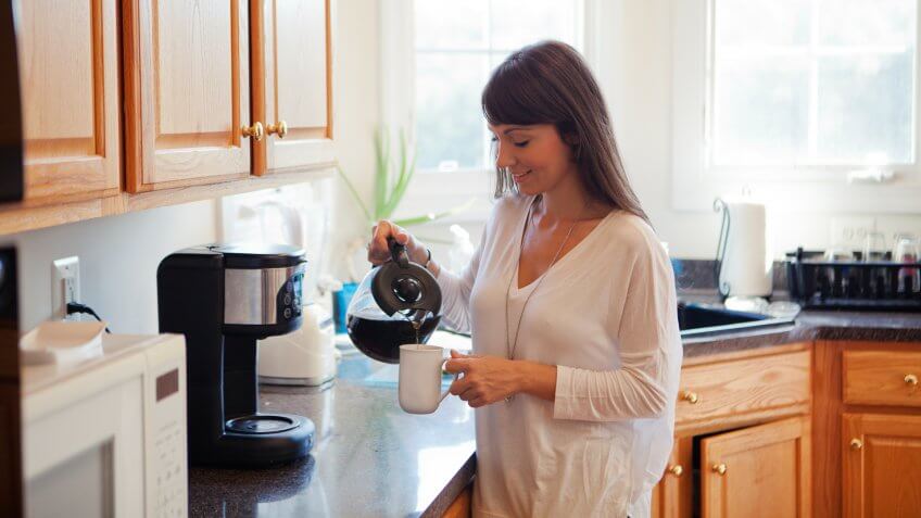 Woman in the kitchen making coffee.