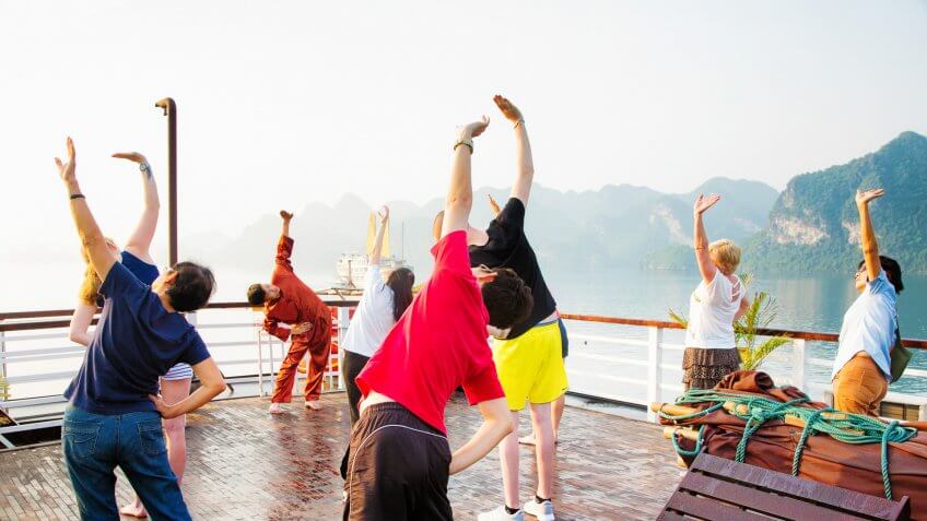 Halong Bay, Vietnam - April 15, 2015: Tourists exercising while on Halong Bay cruise in Vietnam, mimicking the moves of their teacher.
