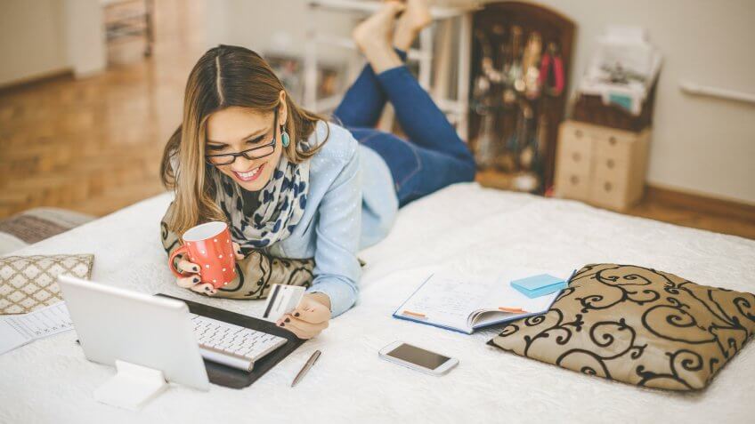 woman laying on bed using a laptop