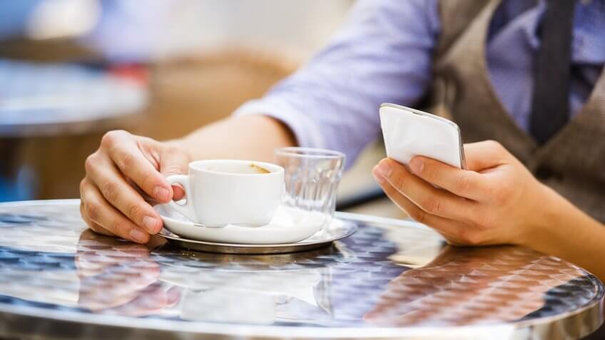 Person on phone drinking espresso Person on phone drinking espresso