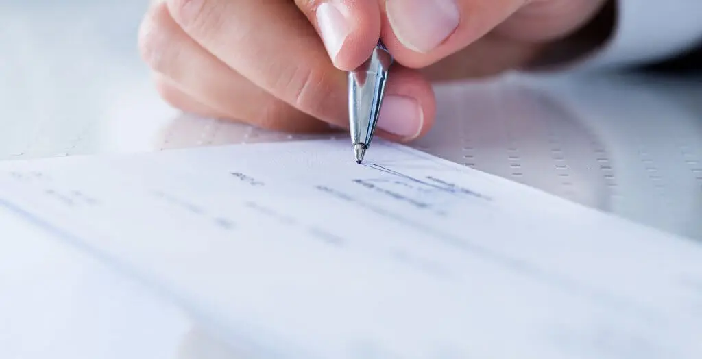 person signing some type of document or check