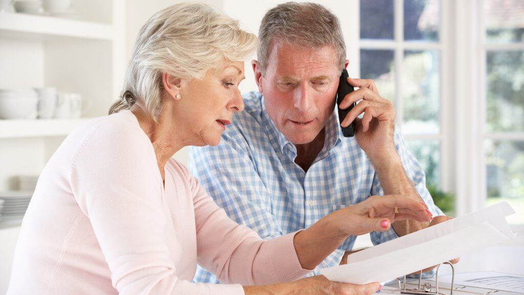 Find out what you spent your retirement savings on. retired couple looking at paperwork and calling someone