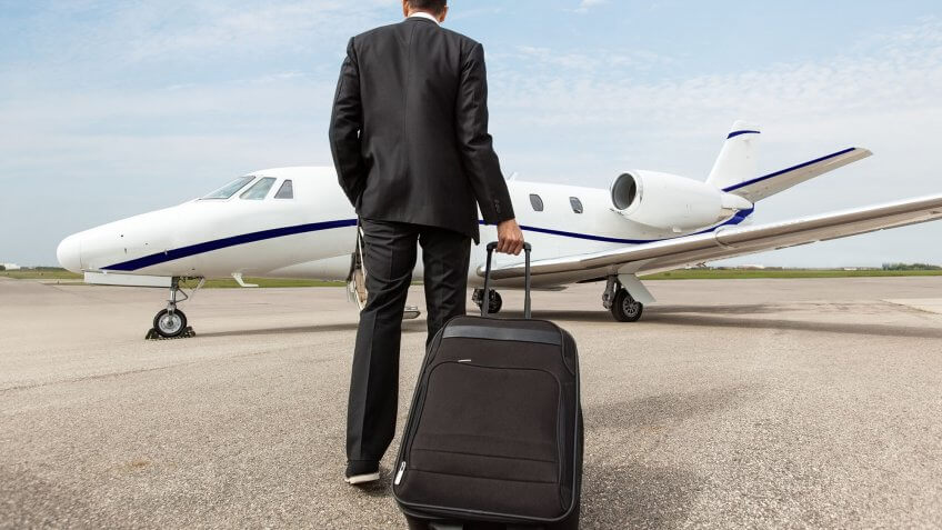 You think you'll be making seven figures by the time you're 30. man with luggage walking toward a private jet