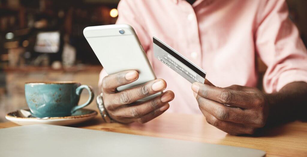 Technology allows for seamless transactions and money management. person holding credit card and phone with coffee