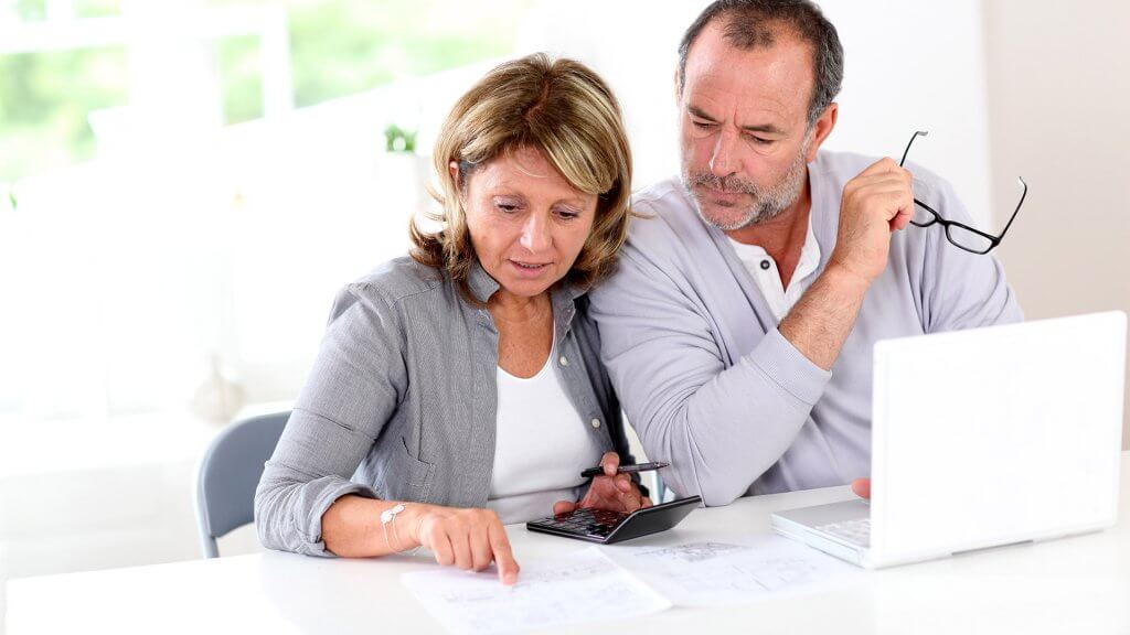 Figure out your retirement income. couple looking at financial statements