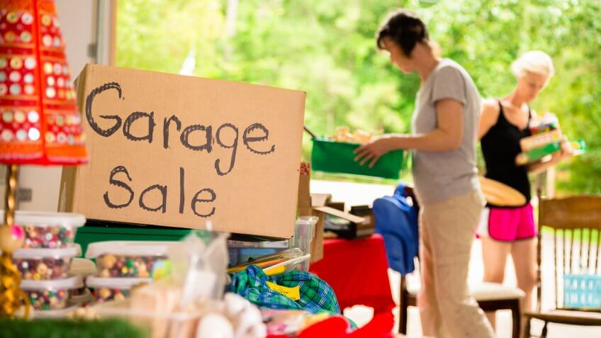 Consumerism: Adult women shopping at a garage sale in suburbs.