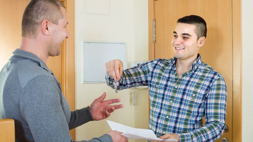 Haggle for lower rent. landlord handing key over to tenant