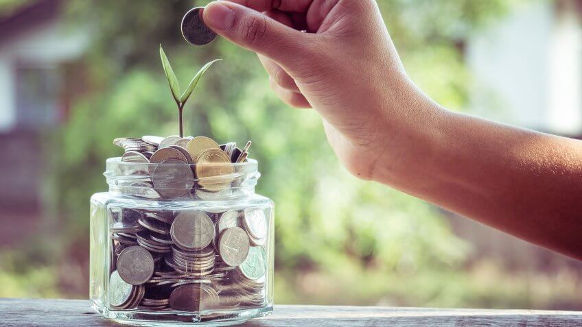 You'll start saving once you've earned enough. person placing coin in full coin jar