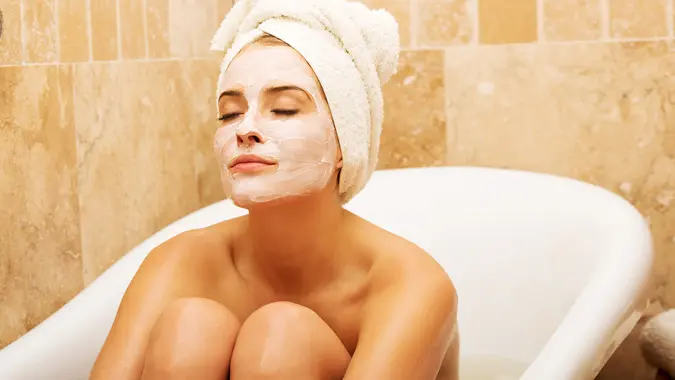woman in bathtub with face mask