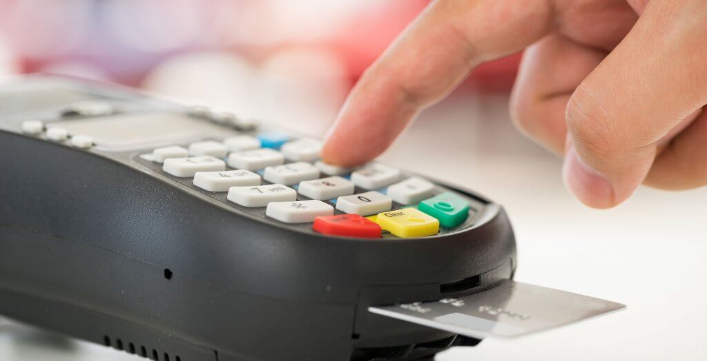 You should change a debit card when there is a strong threat of fraudulent activity. person inserting chip card into machine and entering PIN number