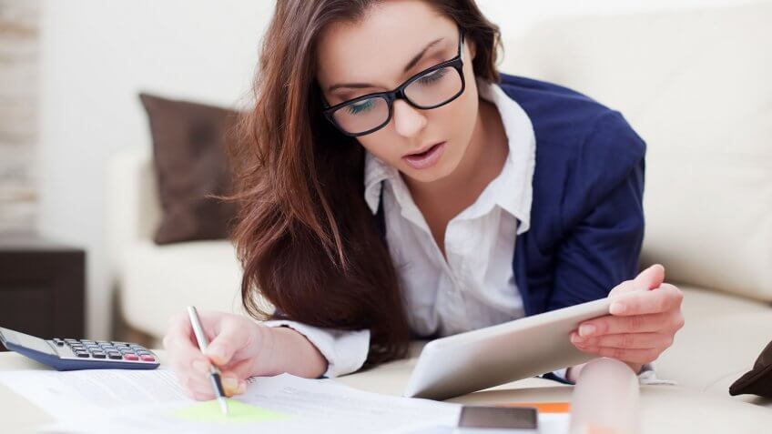 Refinancing your loans can help you save thousands. woman laying on couch working