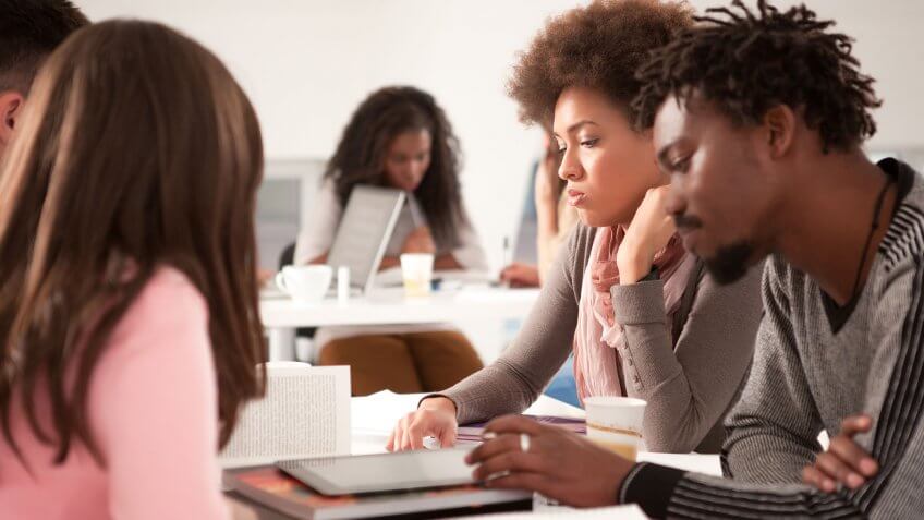 Student loans are the biggest source of debt for millennials. students sitting around looking despondent