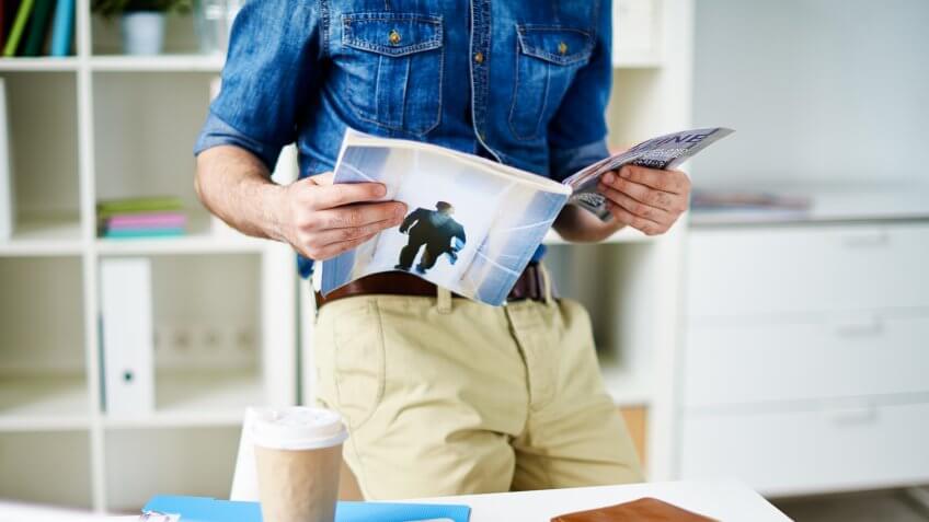 Designer reading a magazine in office.