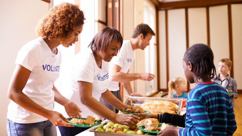 Cropped shot of a group of volunteer workers serving food to childrenhttp://195.