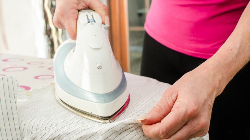 Close up of woman ironing a shirt Close up of woman ironing a shirt