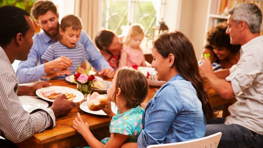 Family and friends sitting at a dining table.