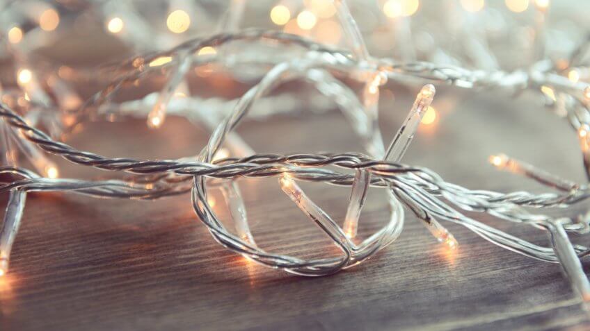 Christmas lights on wooden background.