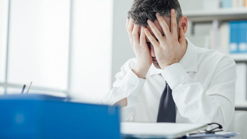I'm not a business school grad or entrepreneur. stressed man covering his face