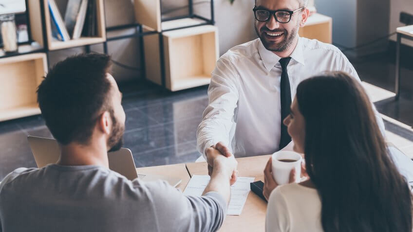 Prove to the landlord that you're not a risk to the property. couple shaking hands with businessman