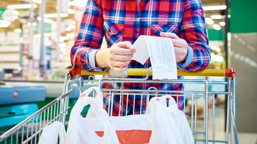 person looking at grocery receipt