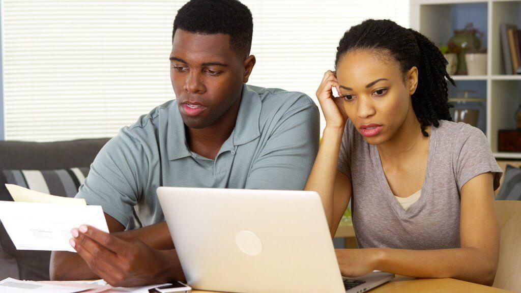 man and woman frustrated at computer and bills