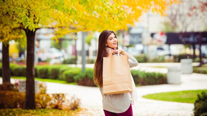 Shot of young women walking down a street carrying shopping bags.