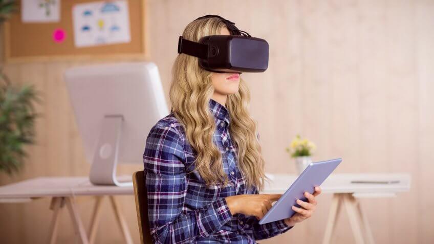 woman wearing vr headset and holding tablet