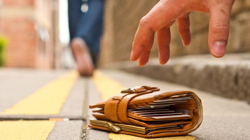 Don't lose your IDs, or anything else that identifies you. person reaching for wallet on the ground
