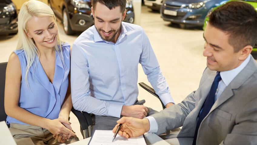 Auto loan debt is highest among high-income earners. couple buying car
