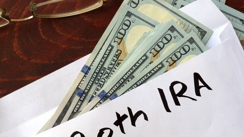 Open a Roth IRA. cash sticking out of an envelope with Roth IRA written on it