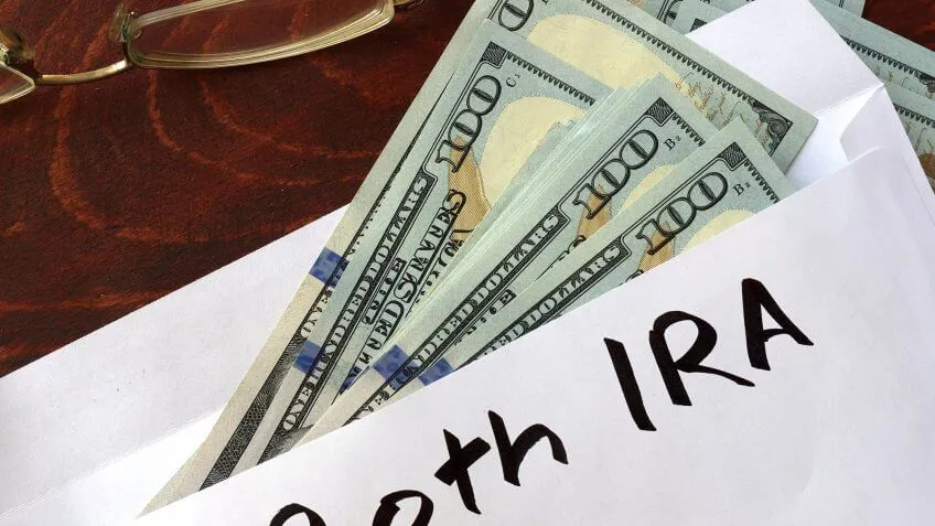 cash sticking out of an envelope with Roth IRA written on it