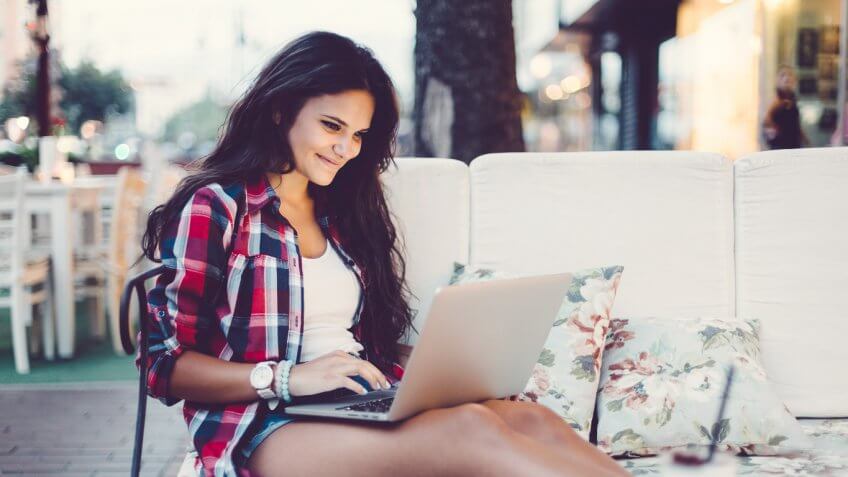 woman sitting outside while on laptop