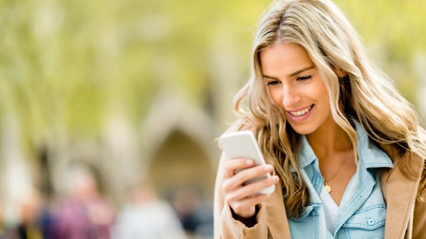 Happy woman texting on her cell phone.