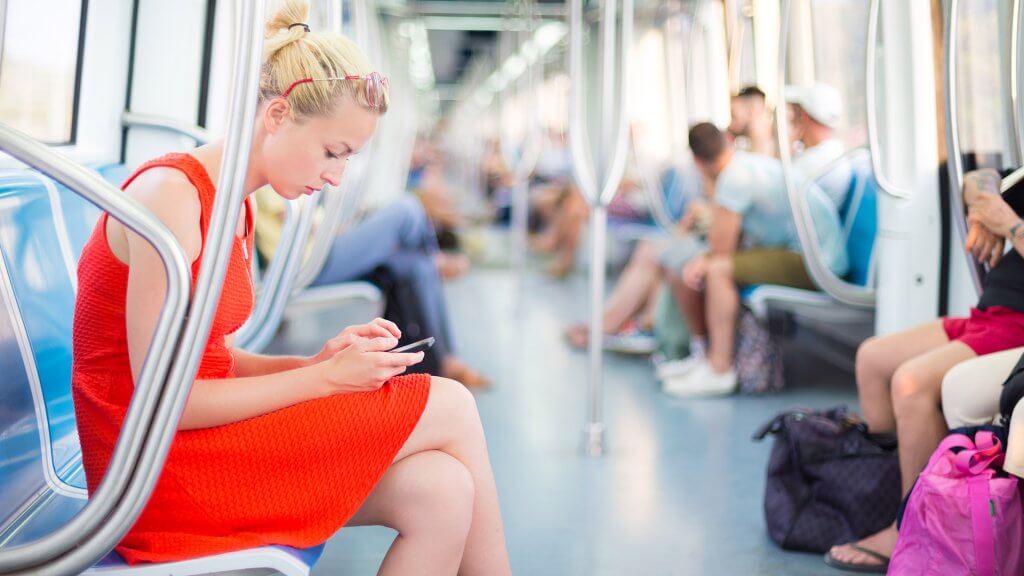 Get the best price on your mode of transportation. woman checking phone on the train