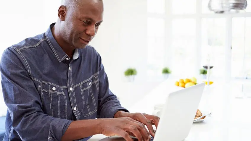 man typing on laptop