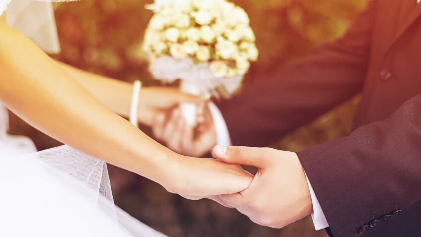 Don't cash out your retirement funds. bride and groom holding hands