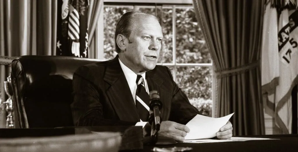 black and white photo of gerald ford sitting in the oval office