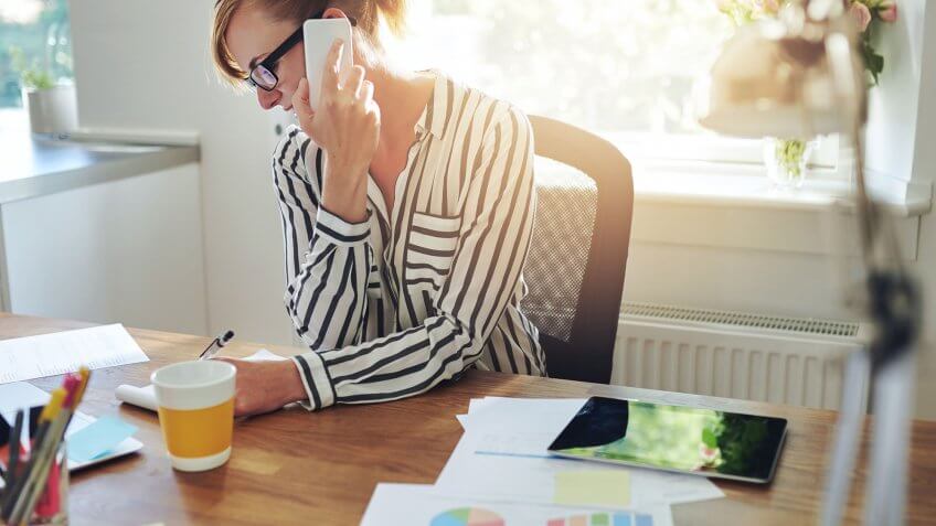 woman on phone working taking notes