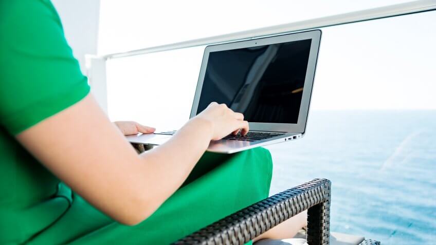 Woman working with a laptop on cruise ship.