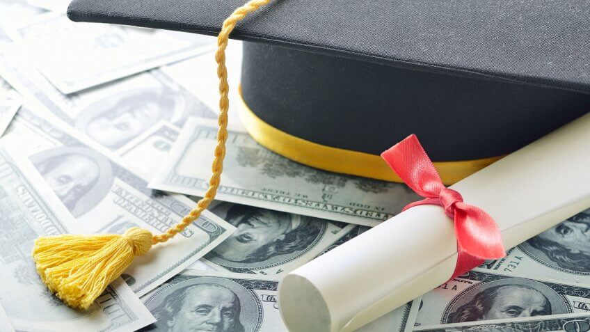 You think your student loans will just be forgiven. grad cap and diploma on top of $100 bills