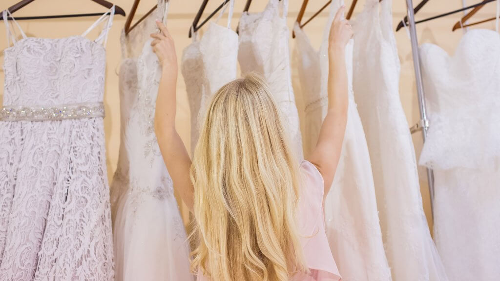 November is a great time to buy wedding dresses. woman looking at wedding dresses