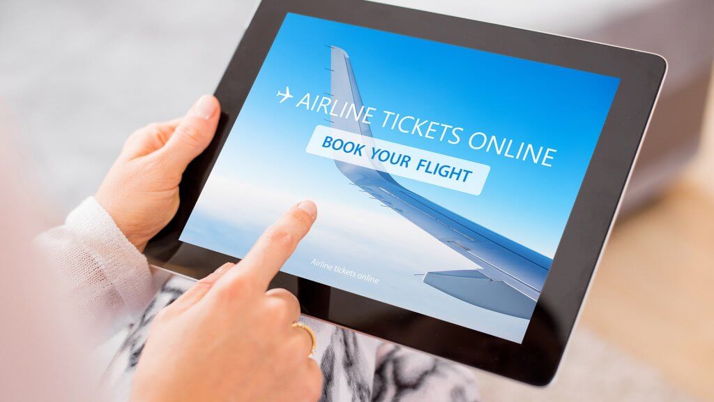 November is in the busiest travel season, so book a trip in advance. hands using tablet to buy airplane tickets