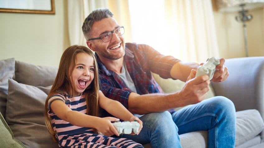Shot of a father and daughter playing video games.