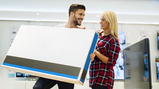 Televisions Young couple buying new 3D TV.