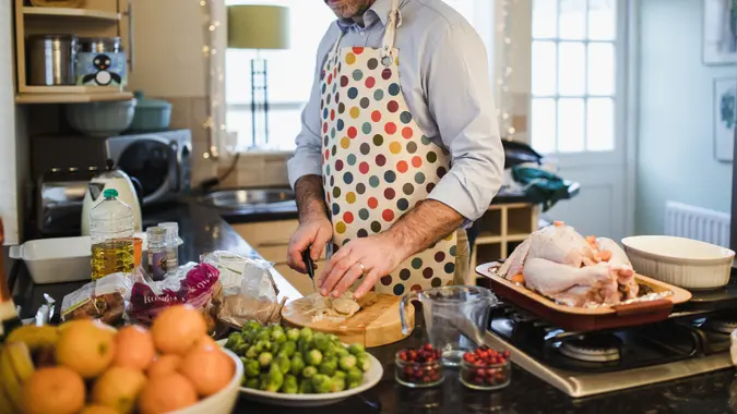 One mature man is preparing a christmas dinner in the kitchen of his home.
