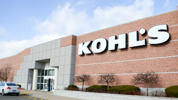 Kohl's storefront. A large brick building with a Kohl's sign and a car sitting in front.