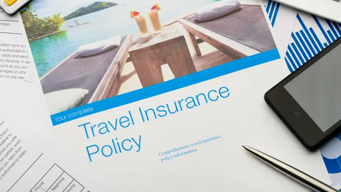 Travel insurance policy document with paperwork and technology.