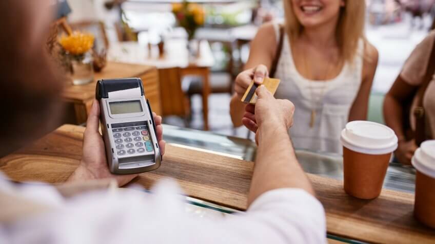 Customer paying for their order with a credit card in a cafe.