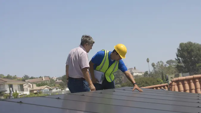 A man working with a professional on his roof